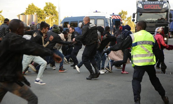 Żandarmeria w Calais próbuje zatrzymać imigrantów przed szturmem Eurotunelu, fot: Daily Express